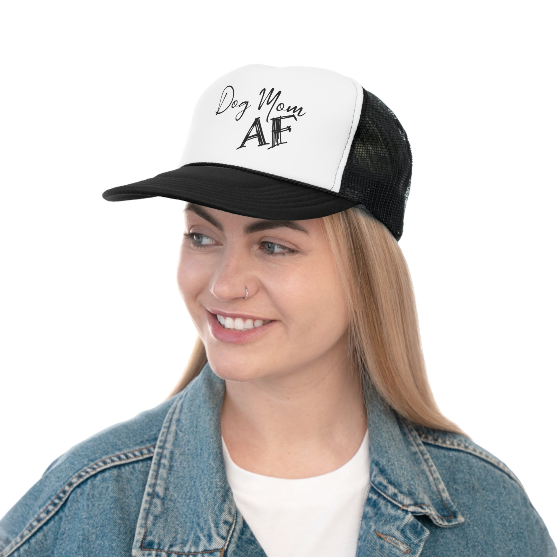 A smiling woman with blonde hair wearing a trucker hat. The hat has a white front panel with the phrase 'Dog Mom AF' in black cursive lettering and a black mesh back.