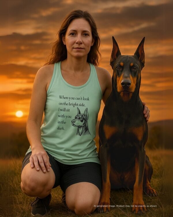 A Doberman mom wearing the tank, sitting on a grassy hilltop with her Dobie pressed close beside her. The sky is moody but beautiful—just like the message. Tank design is clearly visible. Soft lighting, introspective vibe. A quiet moment, shared.